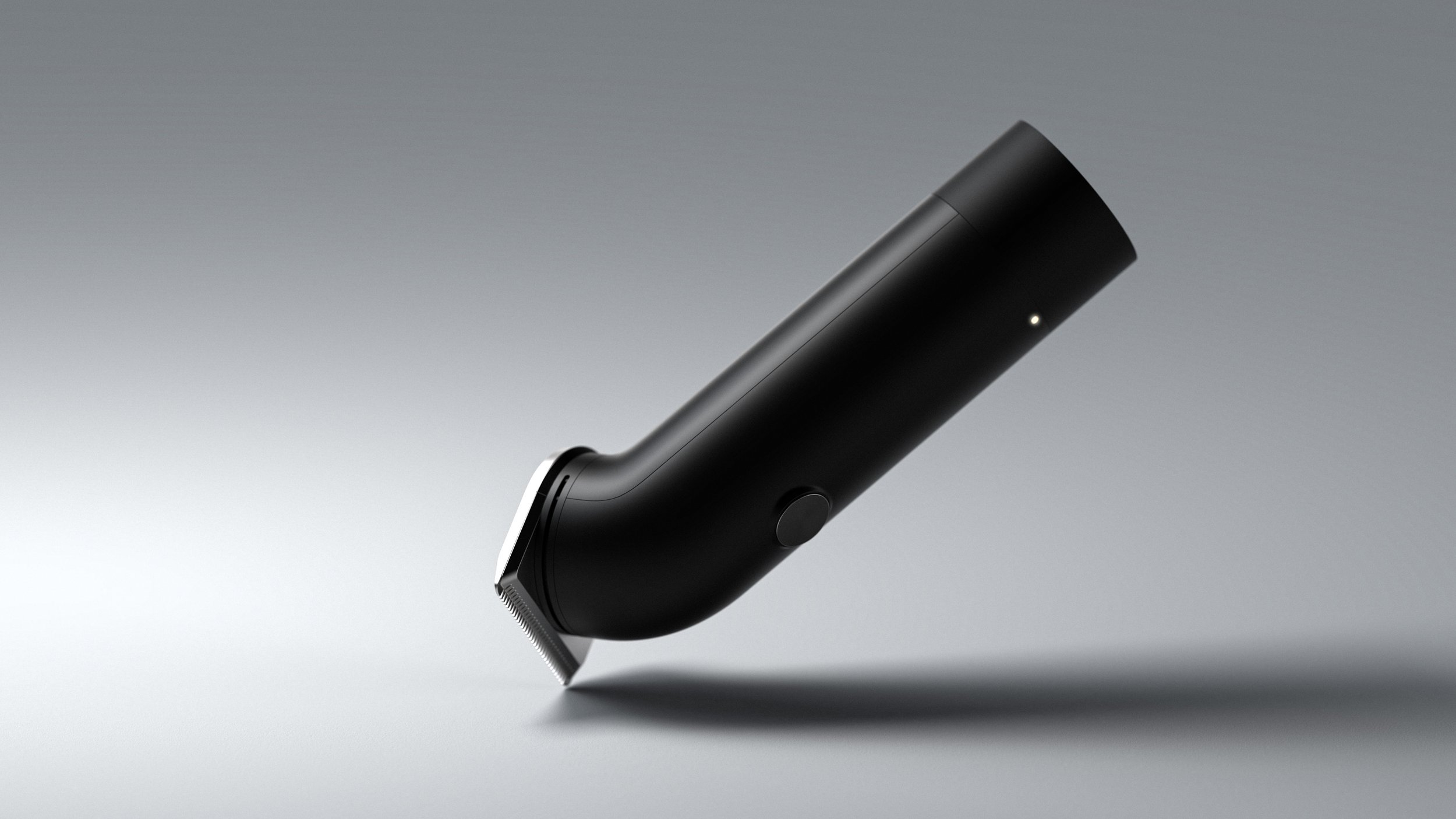 A black electric razor placed on a gray surface with a neutral gradient background.
