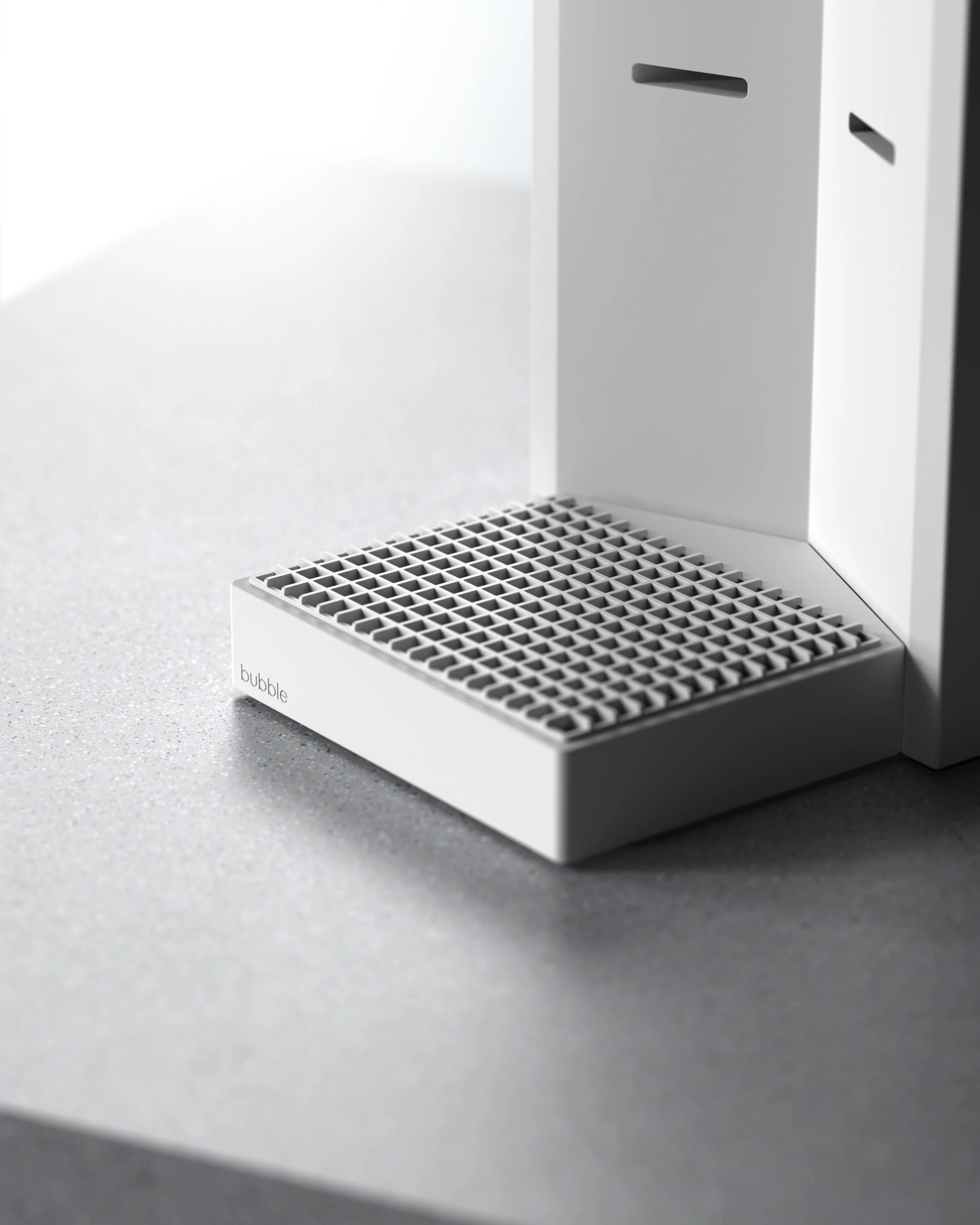 Close-up of a modern white bubble water dispenser with black nozzles and a black textured drip tray on a gray surface.