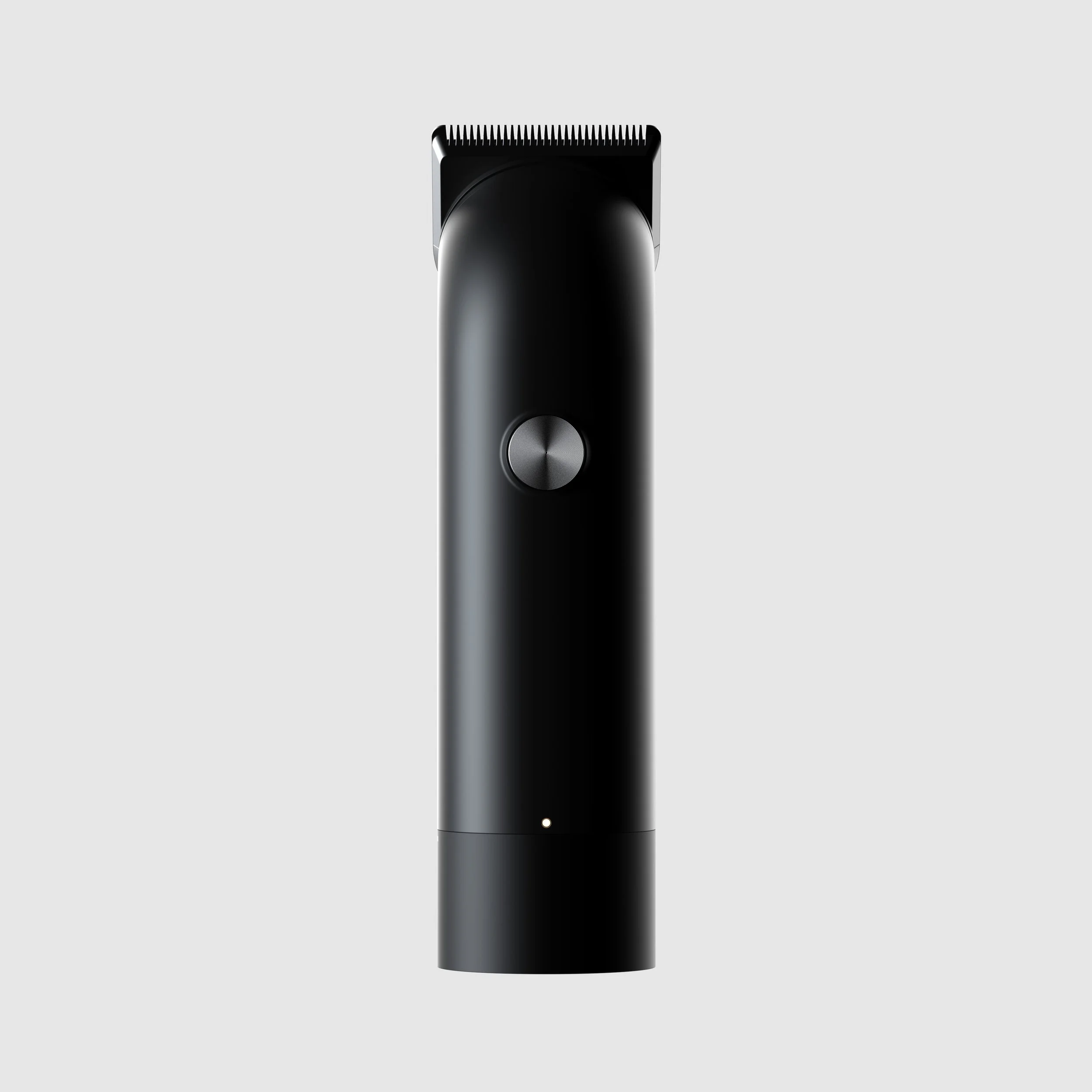 A sleek, black electric hair trimmer with a silver power button in the center, shown against a light gray background.