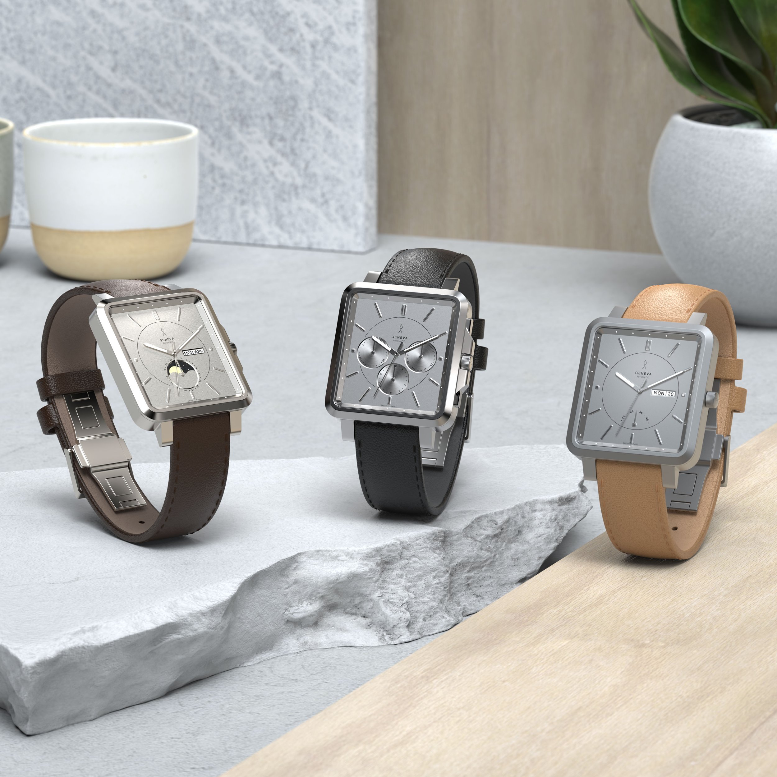 Three modern square-faced wristwatches with leather straps on display, each with different dial features, set on a textured stone and wood surface.