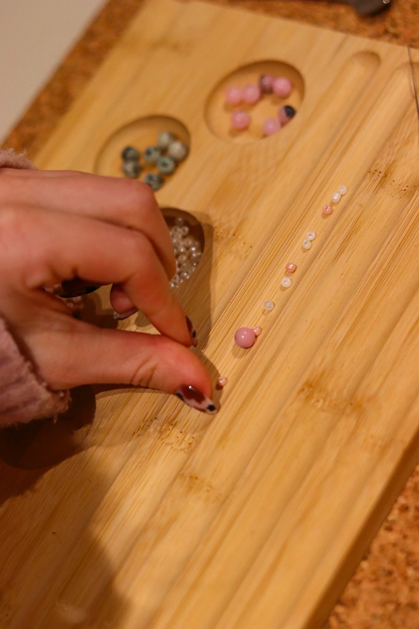 Perlenschmuck Workshop in Hamburg: Teilnehmerinnen gestalten Armbänder und Ketten aus bunten Perlen im hana lima Kreativstudio