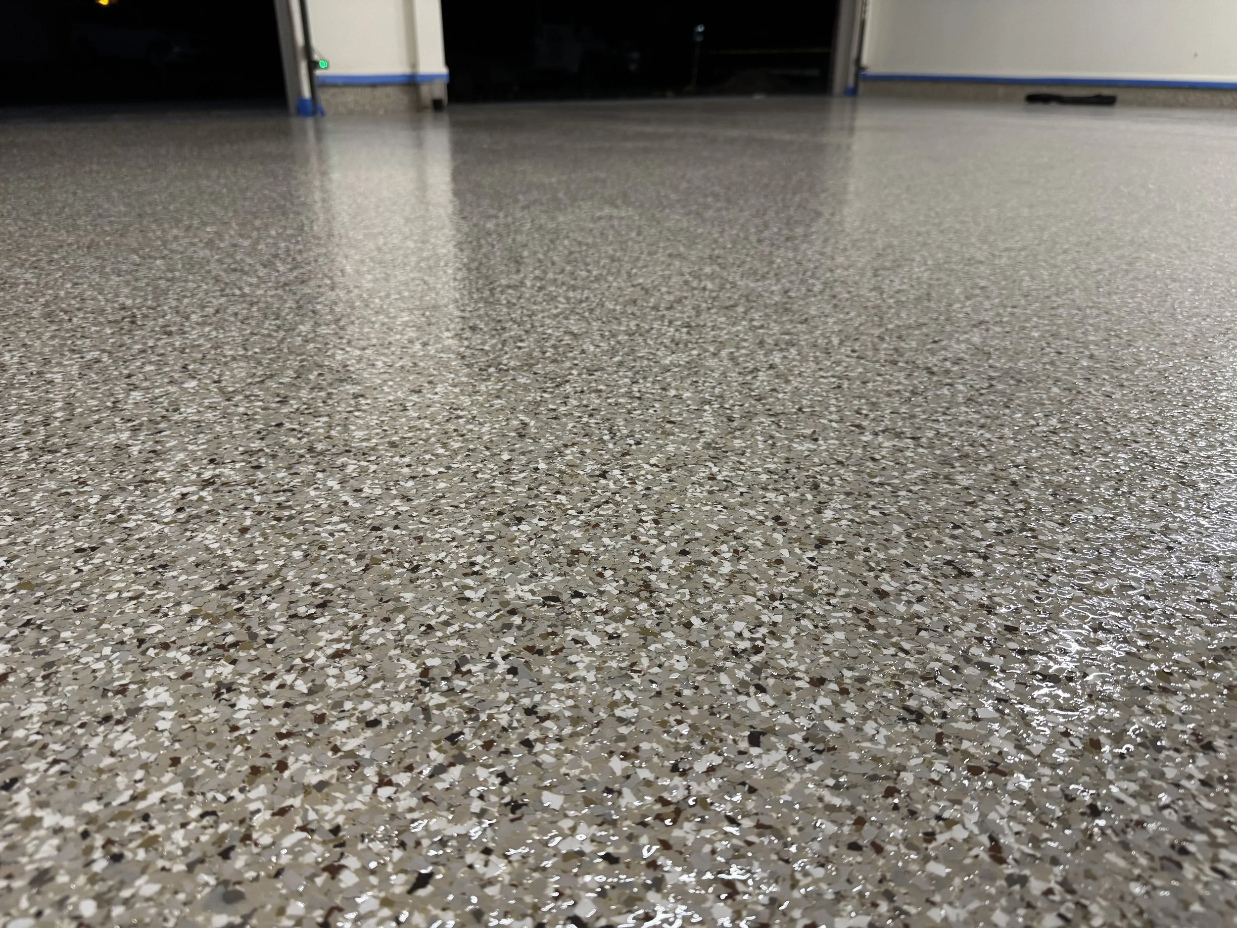 Close-up view of a polished terrazzo floor with a speckled pattern of various colored chips.