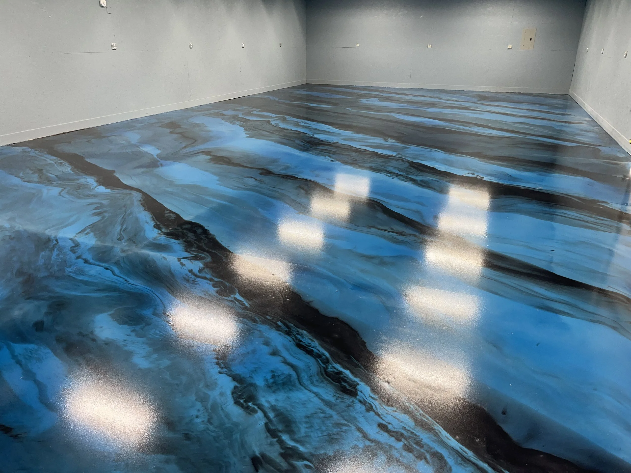 Room with a mural or painted floor resembling swirling blue and black water patterns.