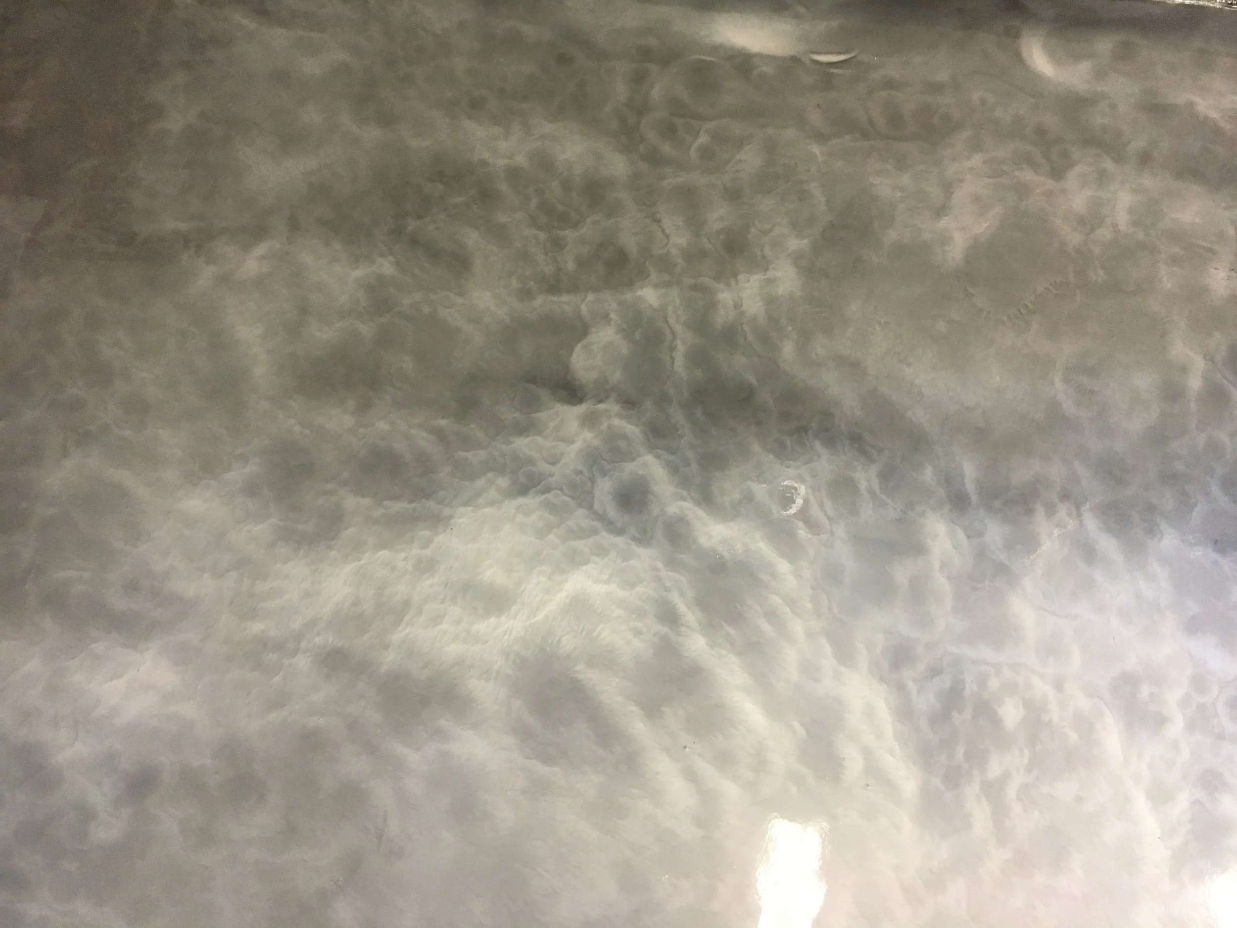 Close-up of a smooth, gray, marble or concrete surface with natural veining and patterns.