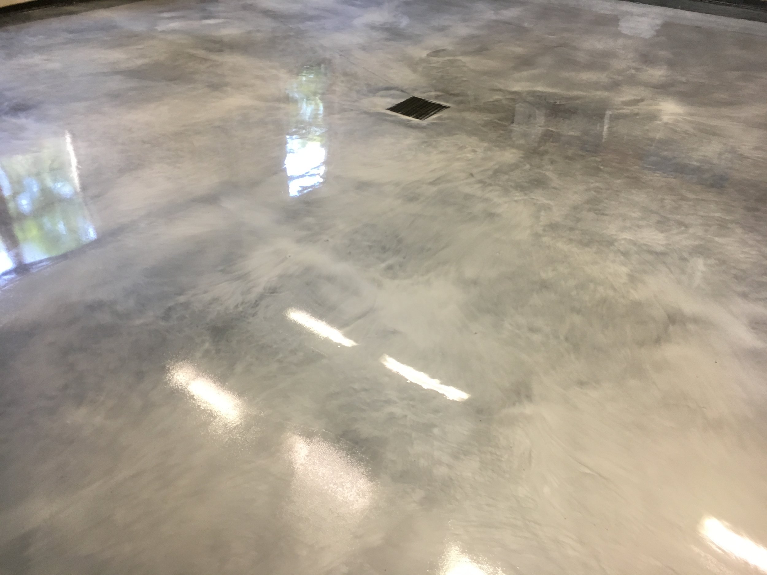 Shiny polished concrete floor with a drain.