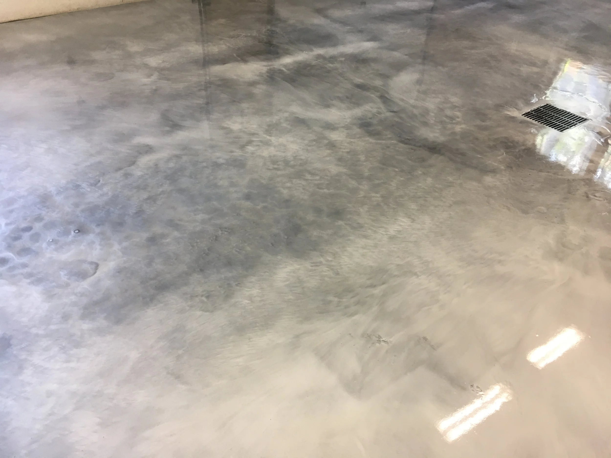 Concrete floor with a drainage grate in the upper right corner.