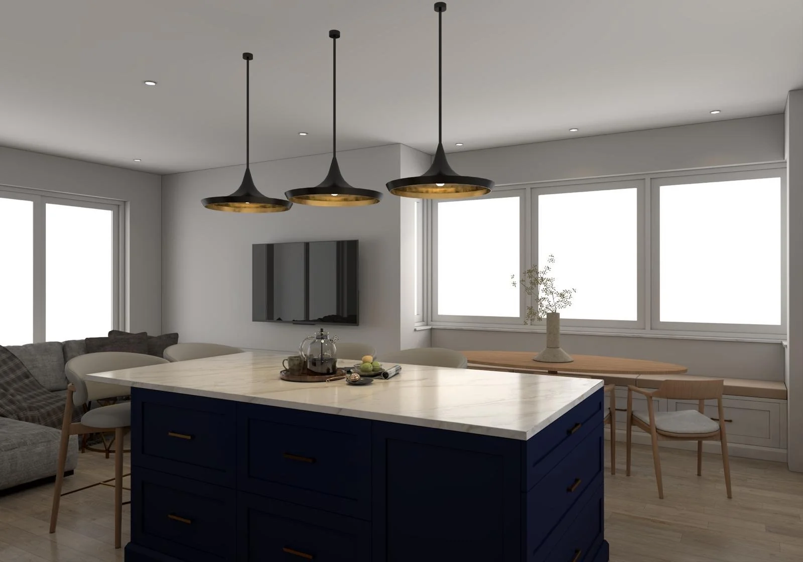 Modern kitchen with navy blue island, white marble countertop, three black hanging pendant lights with gold interiors, large windows, and minimal decor including a vase with branches, a small wooden table with two chairs, and a wall-mounted flat-screen TV.