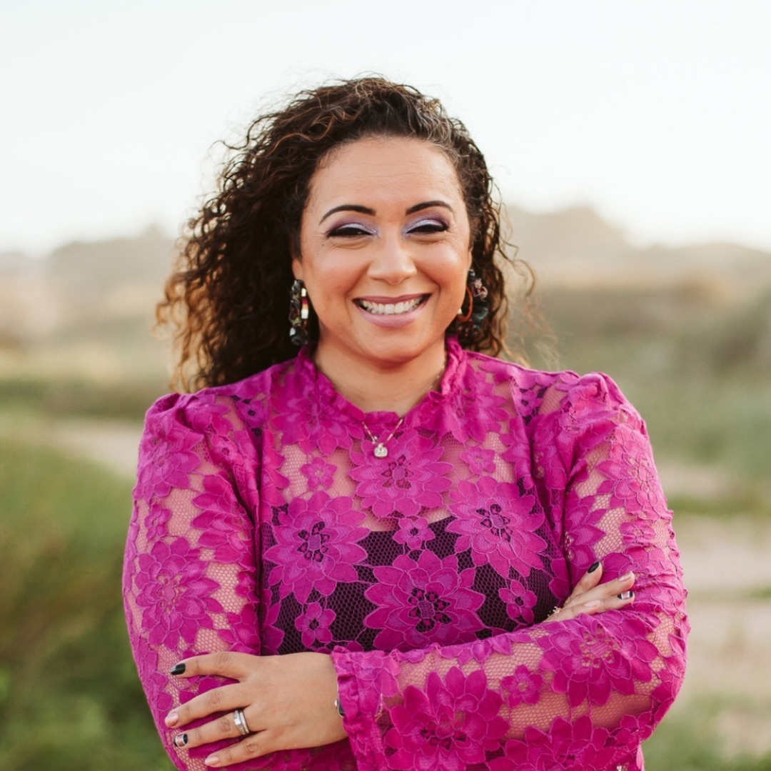 A photo of Mamie Pack wearing a magenta lace top.