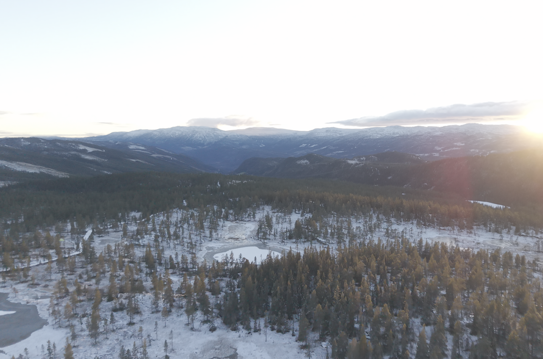 Bilder av fjell, snødekte trær og en innsjø på vinteren ved solnedgang i Norge.