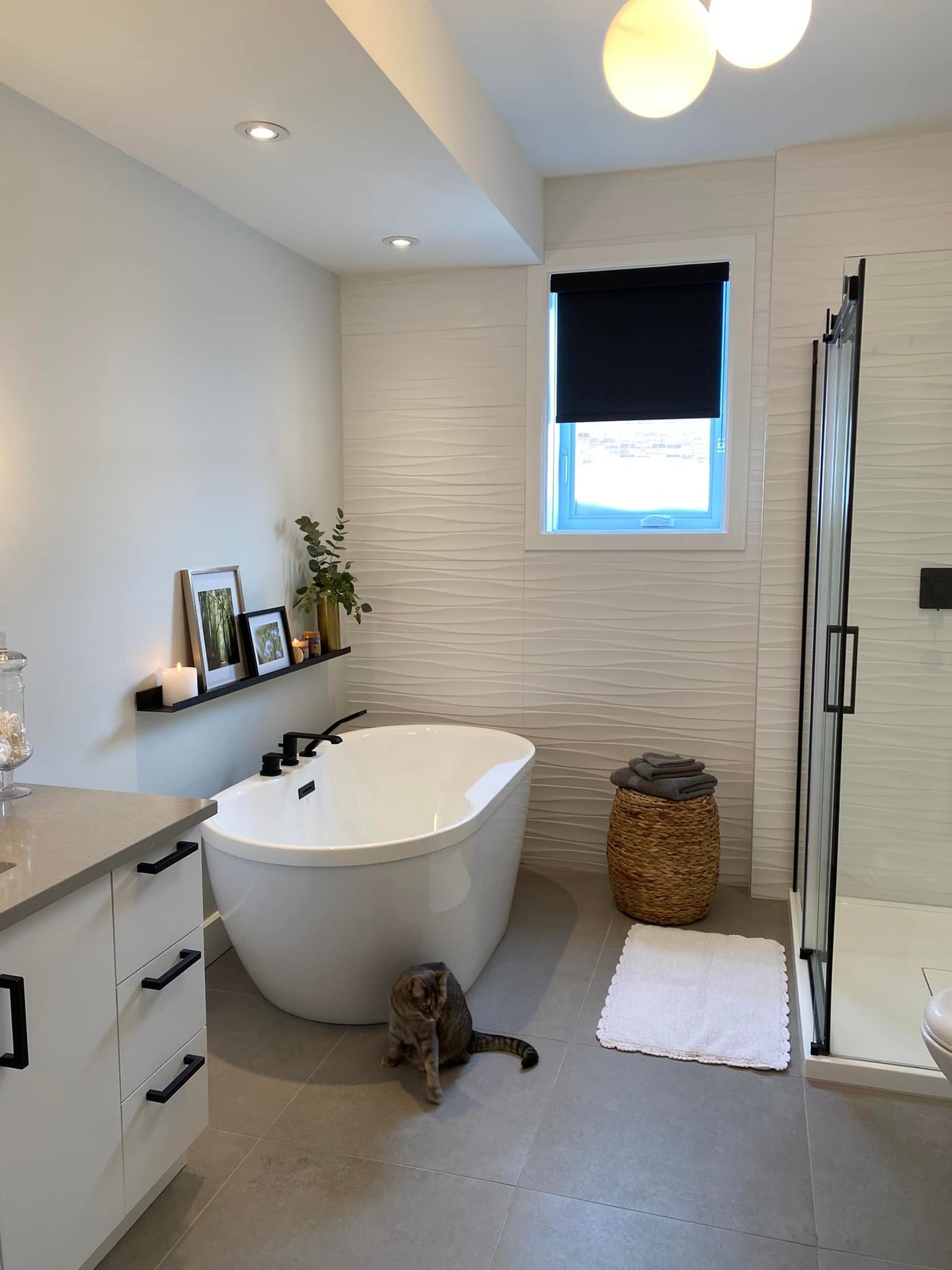 Une salle de bain avec une baignoire, un lavabo et un miroir. Style moderne réalisé par une designer sur la Rive-Sud de Montréal.