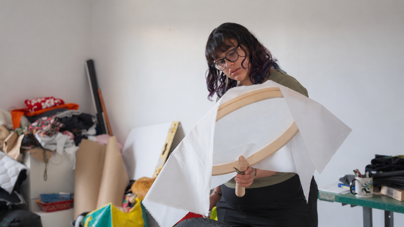Focused Embroidery in a Cluttered Studio.png