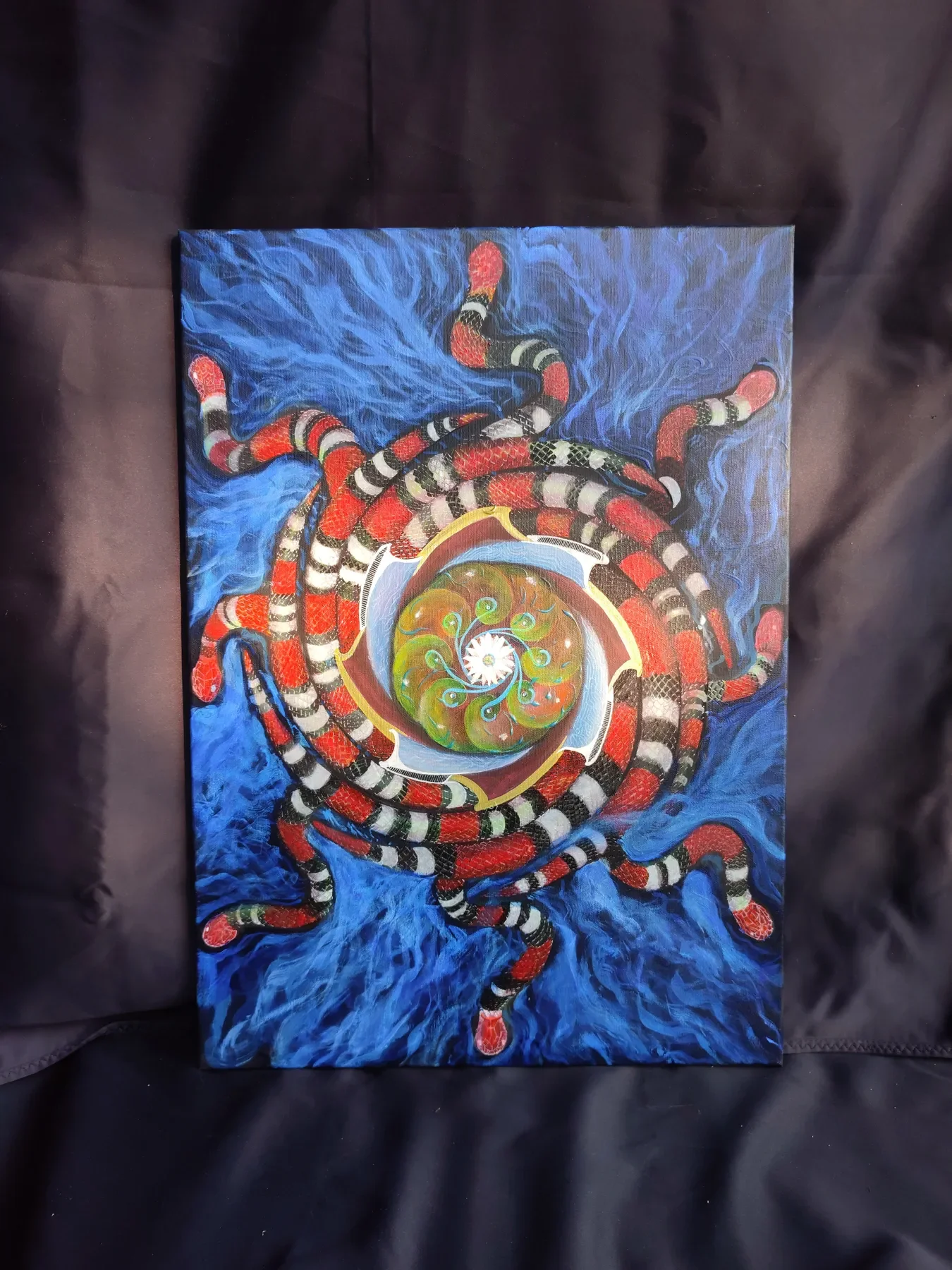 Vue d'ensemble de "Octocoral", oeuvre originale de Tom Dusauvage, artiste visionnaire. Peinture abstraite représentant un motif de type peyotl en spirale au centre, entouré de serpents corails avec des motifs en noir, blanc, rouge, le tout sur un fon