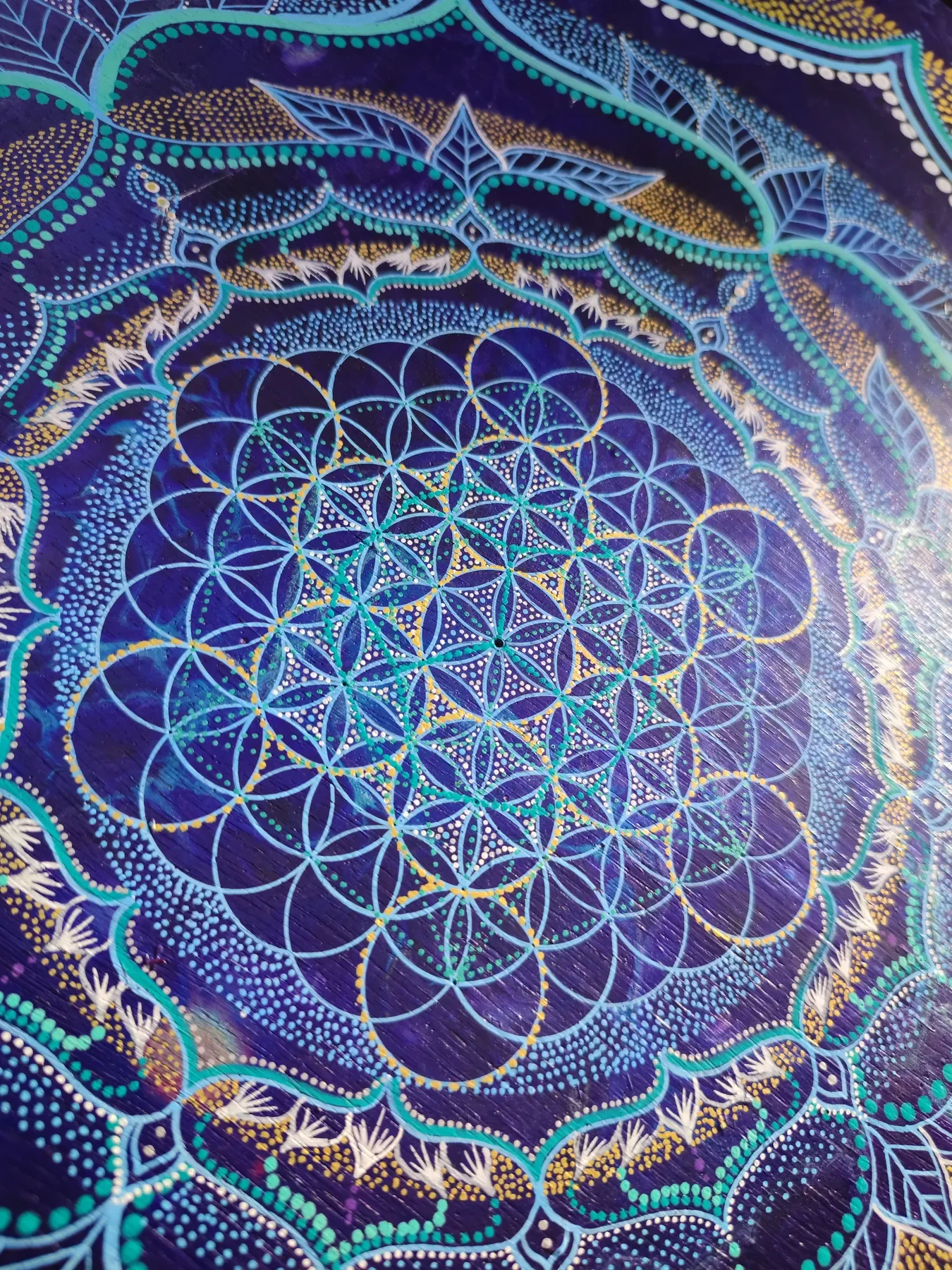 Détails de l'oeuvre "Transpersona" Peinture visionnaire abstraite représentant un mandala de géométrie sacrée, fleur de vie dorée réalisée à la peinture acrylique sur bois par l’artiste Tom Dusauvage.