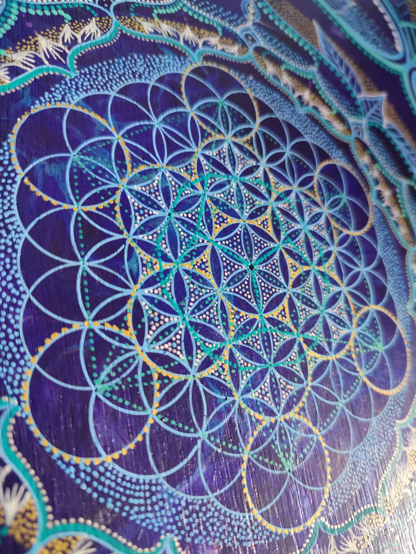 Détails de "Transpersona" oeuvre de Tom Dusauvage. Le dodécaèdre pentagonal inscrit dans une fleur de vie lumineuses en bleu, blanc et jaune.