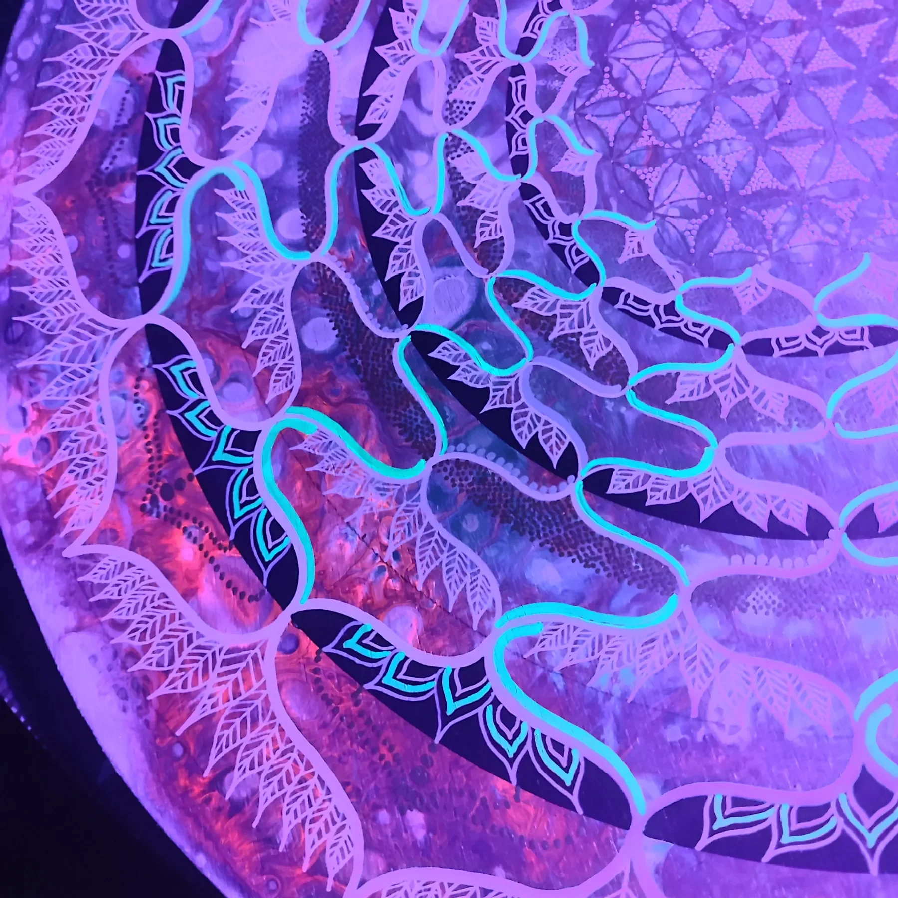 Vue nocturne sous lumière UV de l'oeuvre "Ecstatic Trance" Mandala aux couleurs fluorescentes de l'artiste visionnaire Tom Dusauvage, mêlant symétrie, cercles et formes organiques dans une approche visionnaire