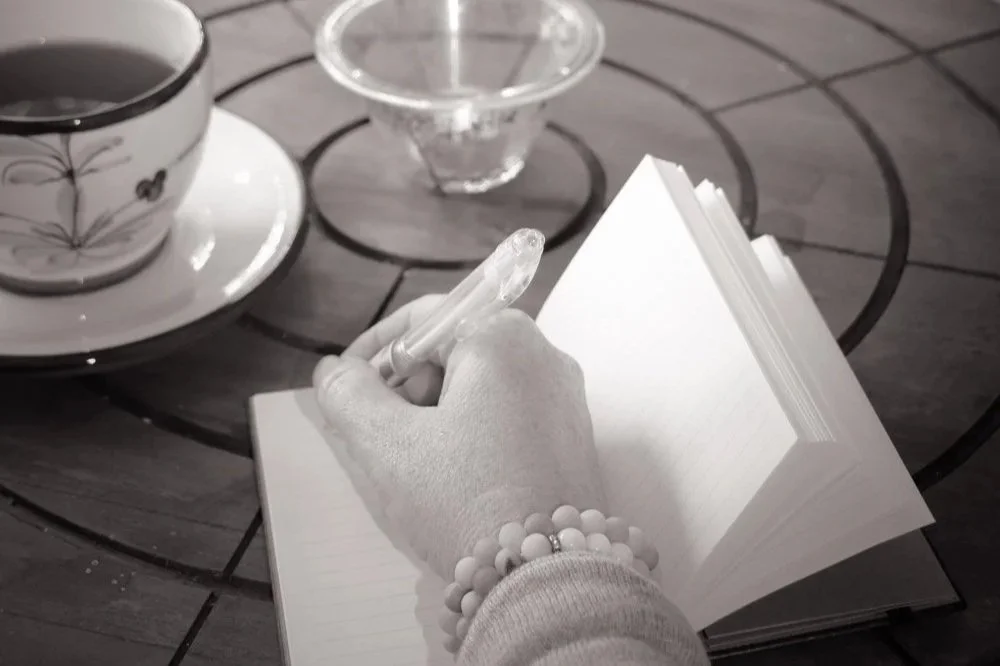 Skriver affirmasjoner i journal i lysthuset, mindfulness, selvomsorg og mentalt velvære.