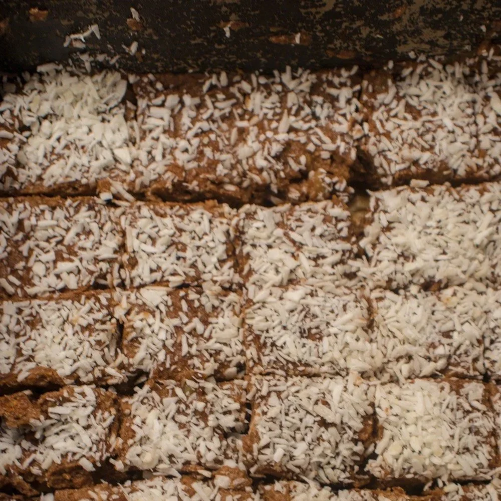 Nærbilde av nøttekladdekake skåret i biter med synlige valnøtter og kakaofarge