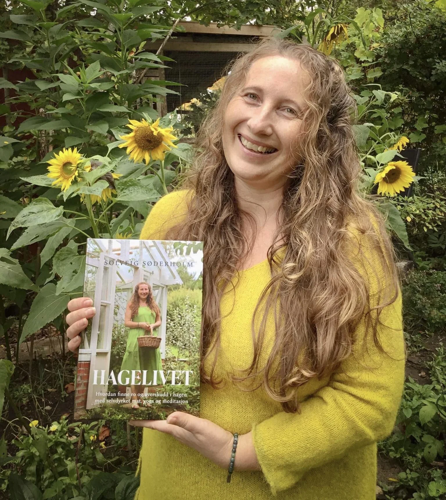 forfatter Solveig Søderholm viser frem boken Hagelivet ute i hagen
