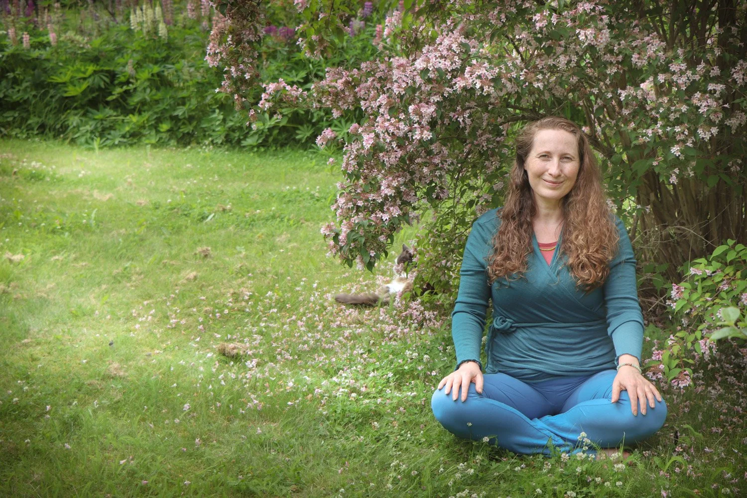 kvinne sittende i hagen for indre ro og mindfulness ute i naturen