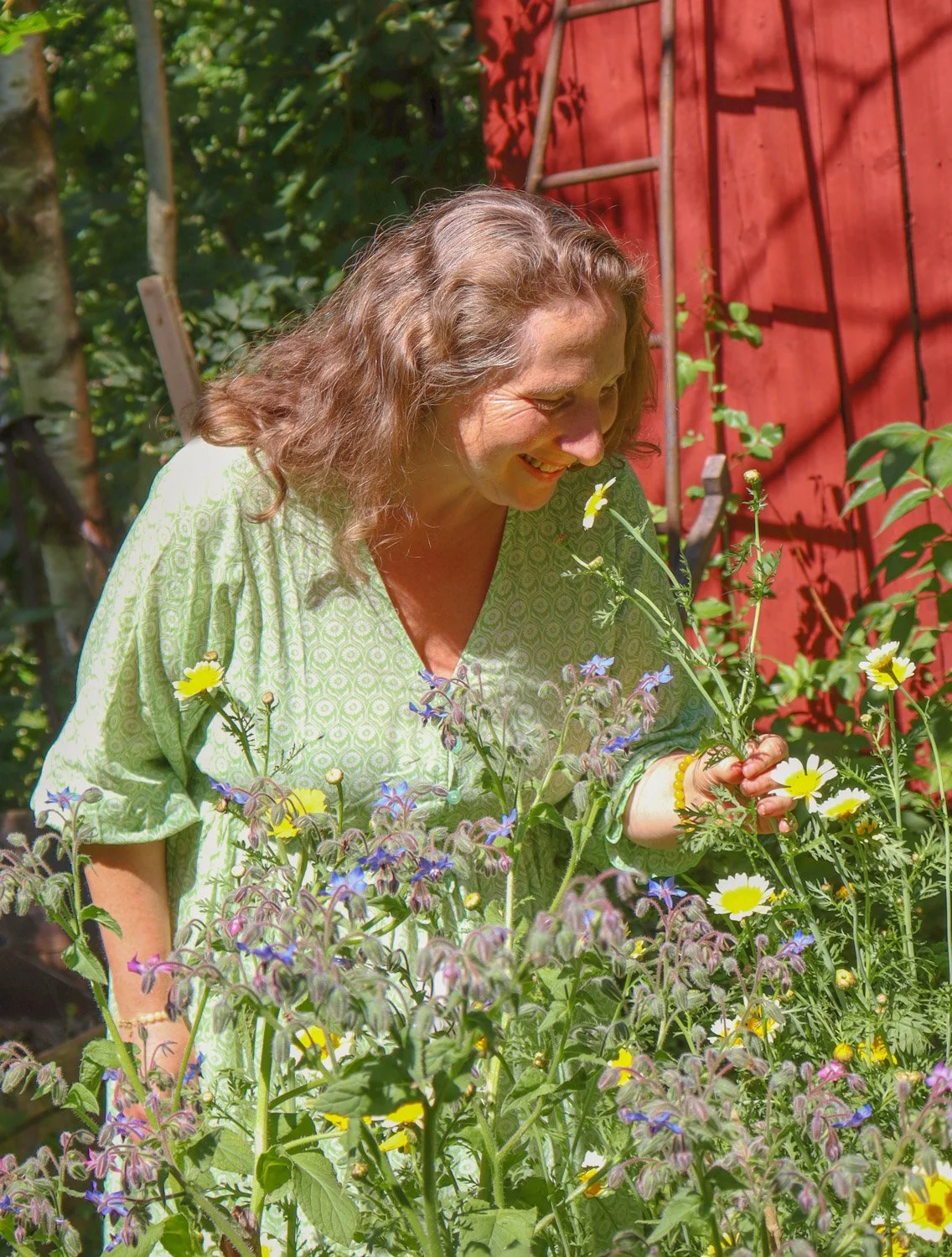 en kvinne dufter på blomstene i hagen som en meditasjon