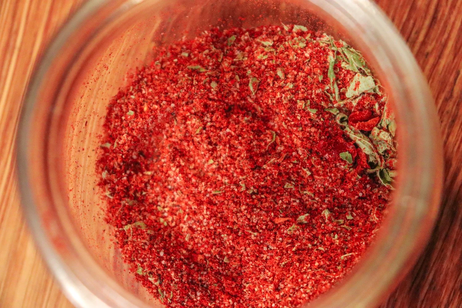 Hjemmelaget tacokrydder i et lite glass med paprikapulver, spisskummen og chili på kjøkkenbenken