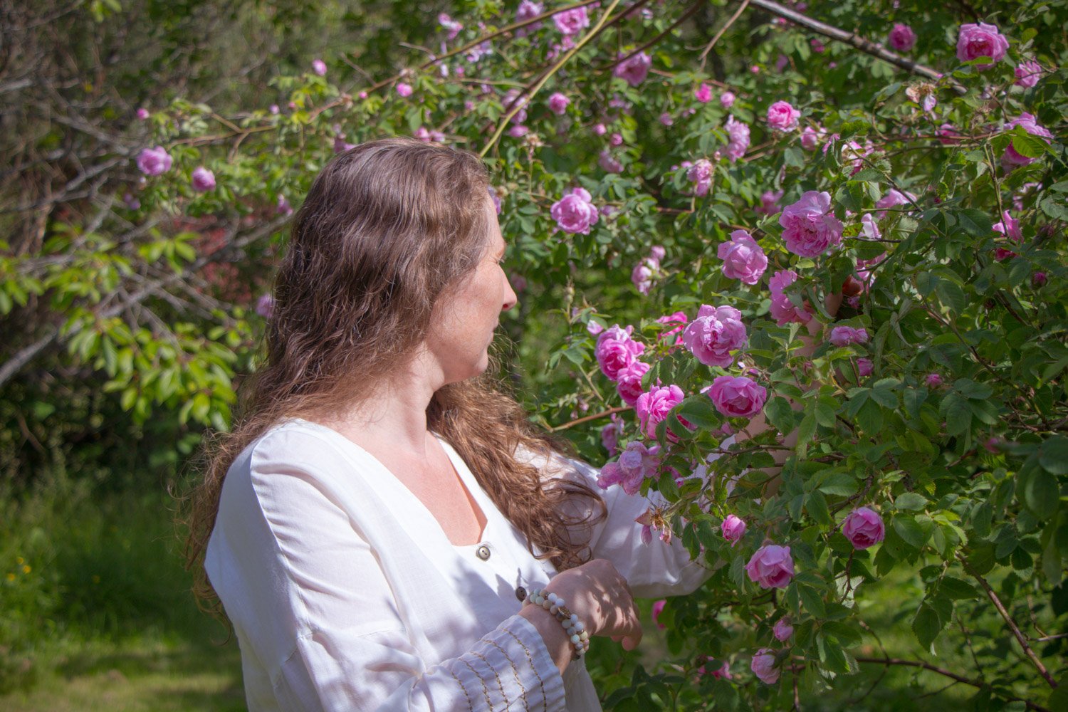 kvinne lukter på roser i hagen som meditativ øvelse