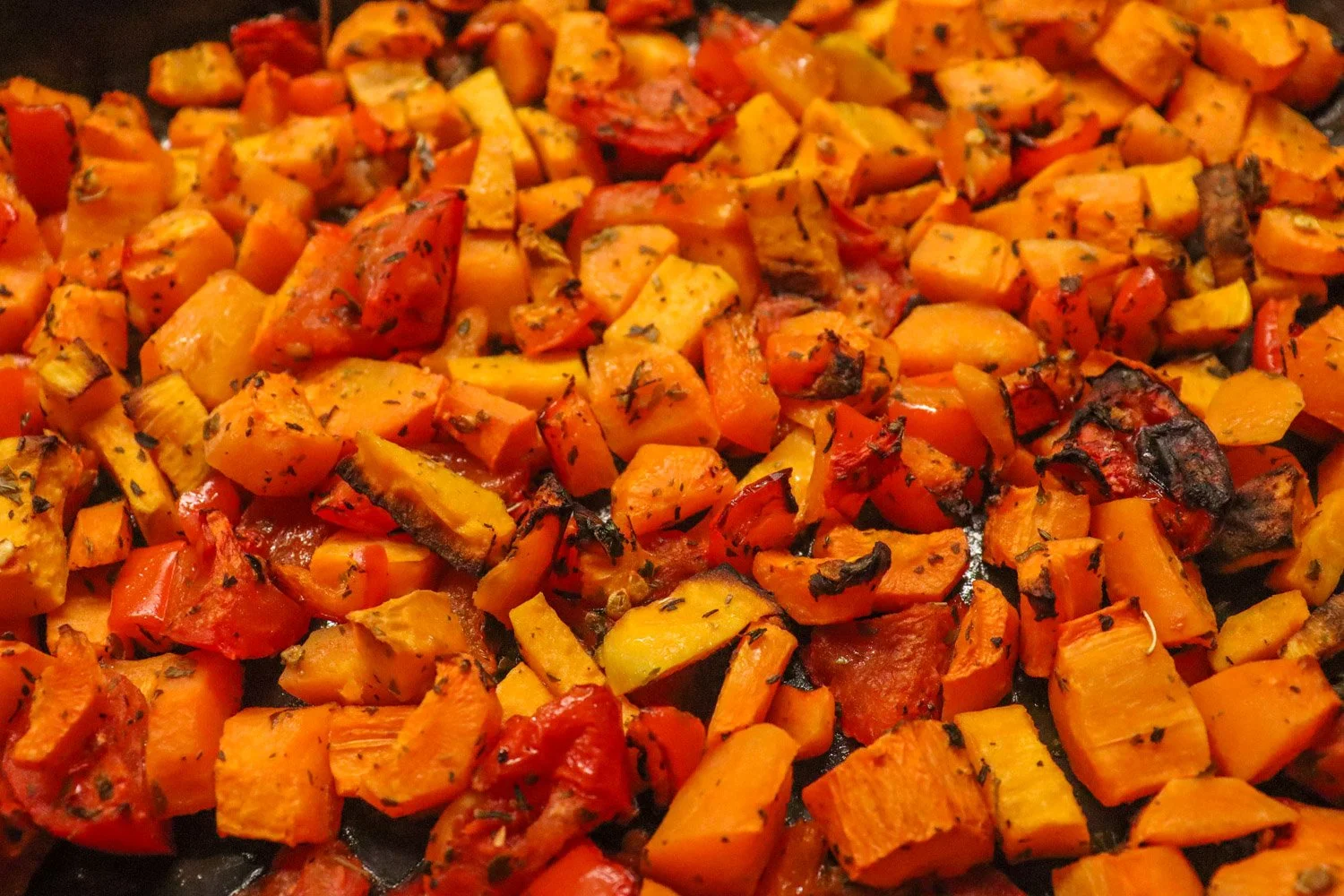 Ovnsbakte gulrøtter, søtpotet, tomat, løk og chili i ildfast form, krydret med tørkede urter og olivenolje før blending til suppe.