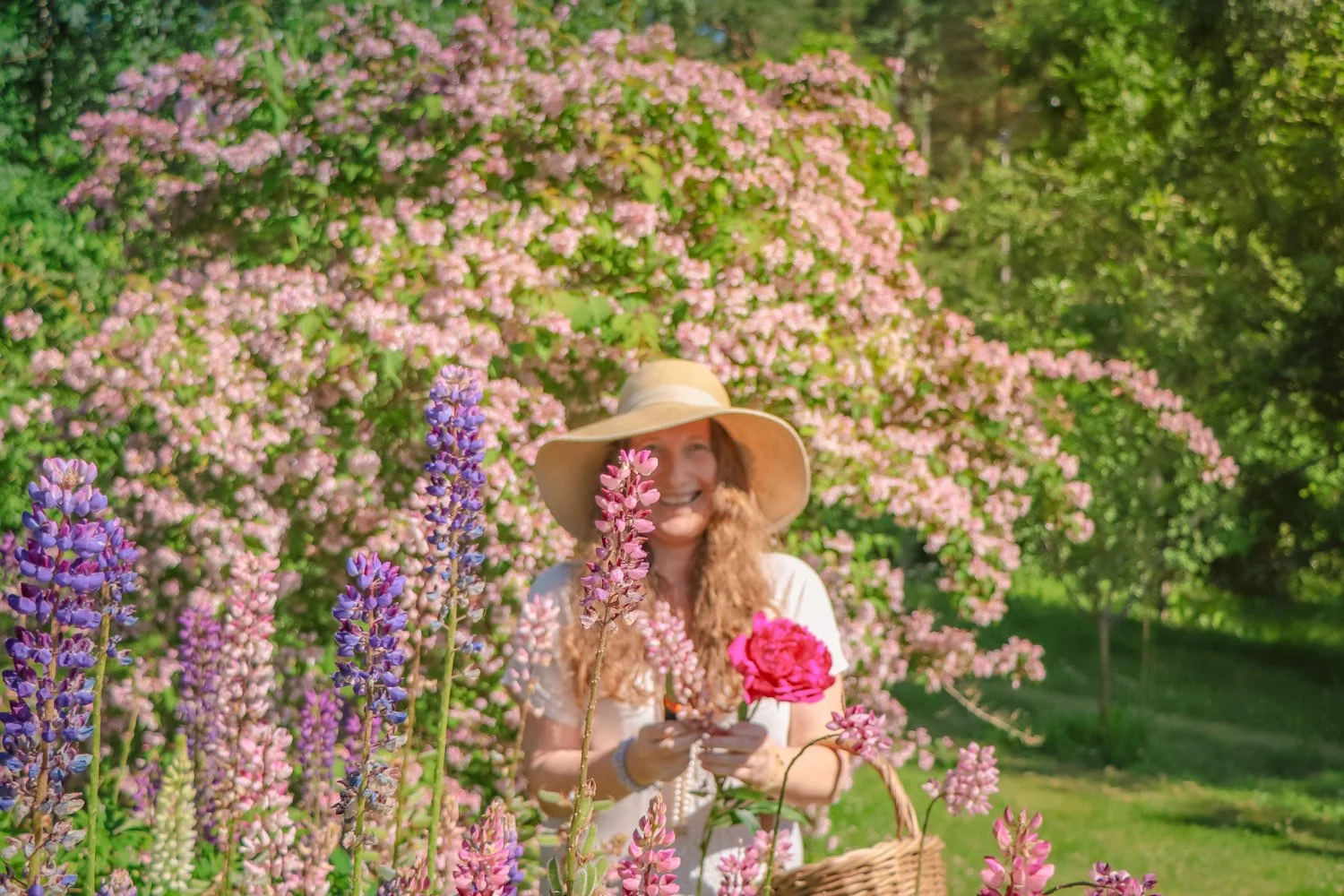 Kvinne plukker blomster i sansehagen