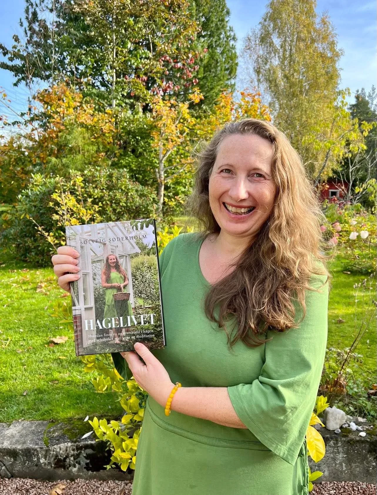 forfatter Solveig Søderholm viser frem boken Hagelivet ute i hagen