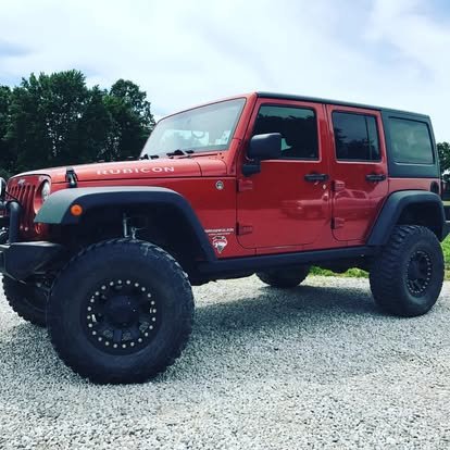 Custom Jeep Wrangler with lift kit to fit off-road wheels and tires. Tinted windows.