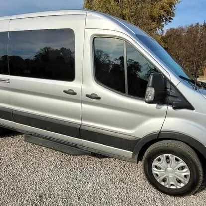 Ford passenger van with window tint and windshield tint. Fitted with running boards. 