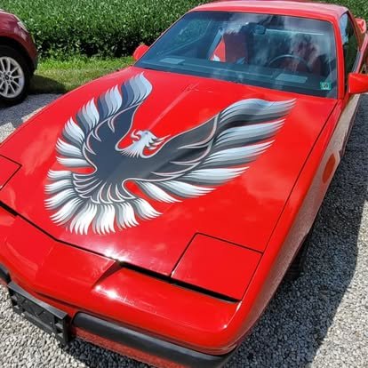 Red Pontiac Fire Bird with hood decal.