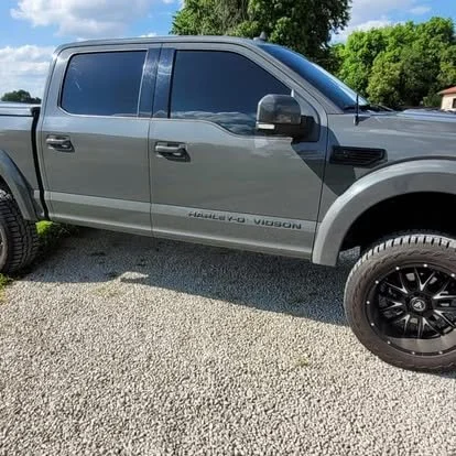 A custom Ford F150 with window and windshield tint. Lifted with custom wheels and tires. 