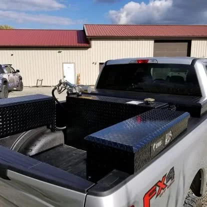 Ford Super Duty with custom-fit tool boxes in the bed along with a fuel transfer tank and B&W Gooseneck Hitch.