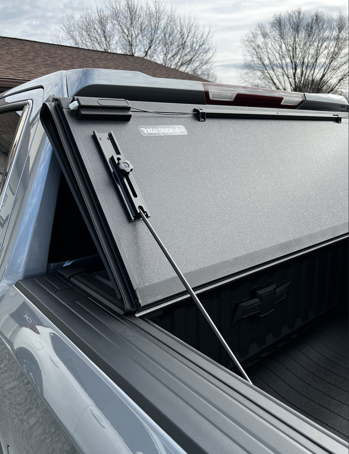 Real Truck MX4 hard-folding tonneau cover raised to view the entire bed of the pickup.