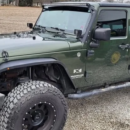 Jeep Wrangler lifted to fit custom off-road wheels and tires. Window tint and LED light bar.