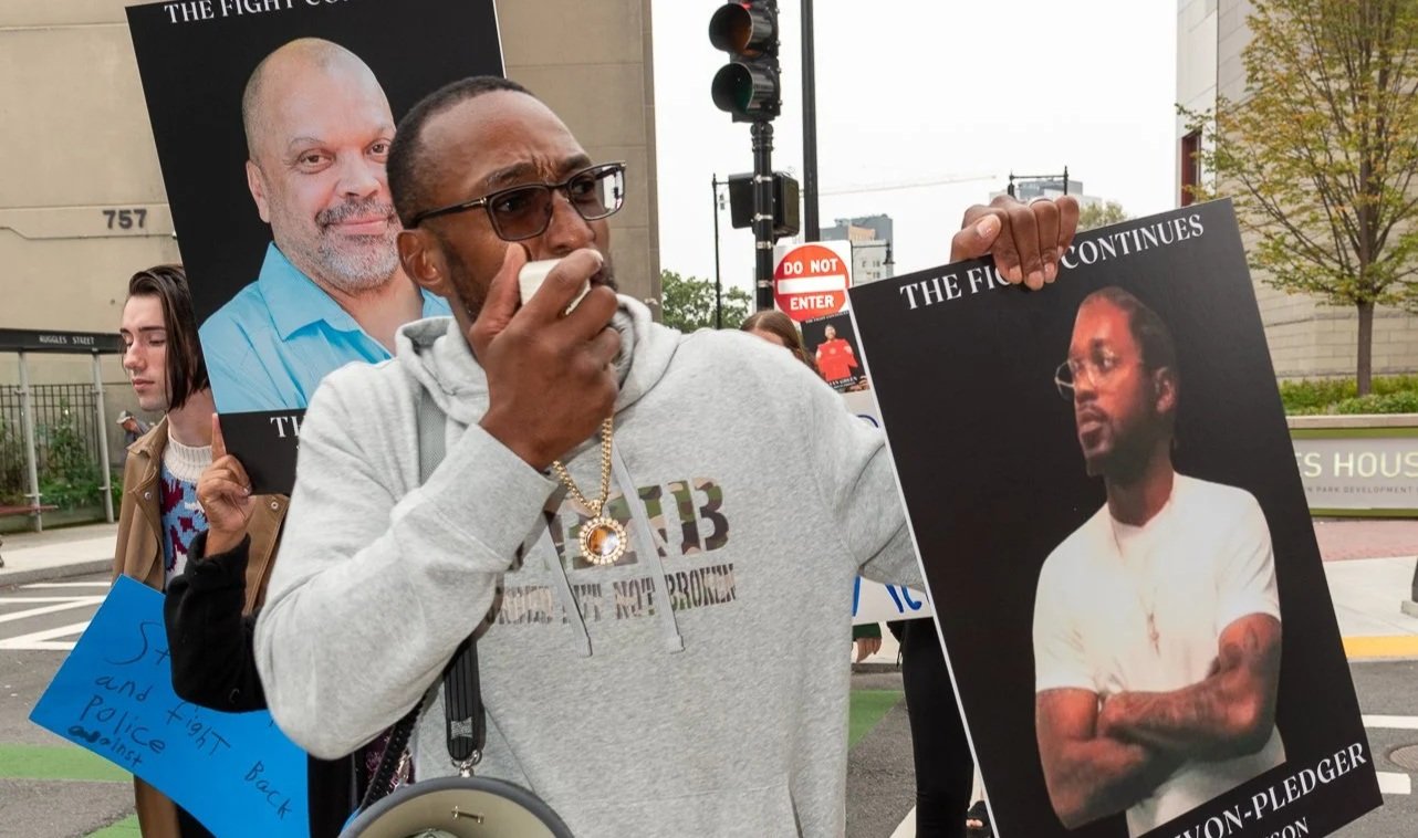 Sean marching at Wrongful Conviction Day, holding posters of those wrongfully convicted