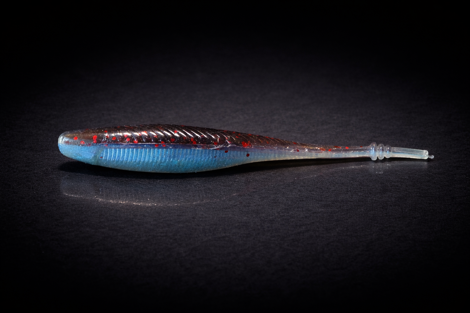 Vibrant fishing lure on black surface.png