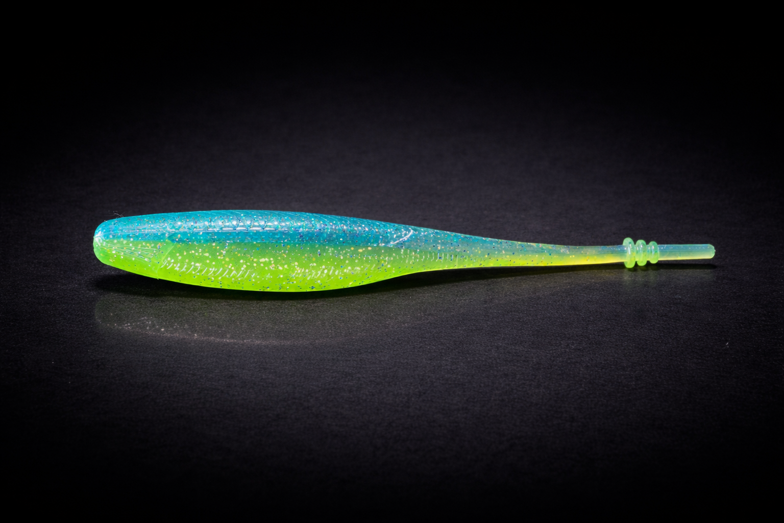Vibrant fishing lure on black surface-2.png