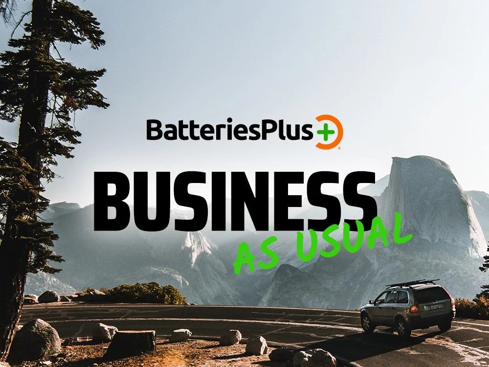 A scenic mountain landscape with rock formations and trees, with a car on a mountain road.