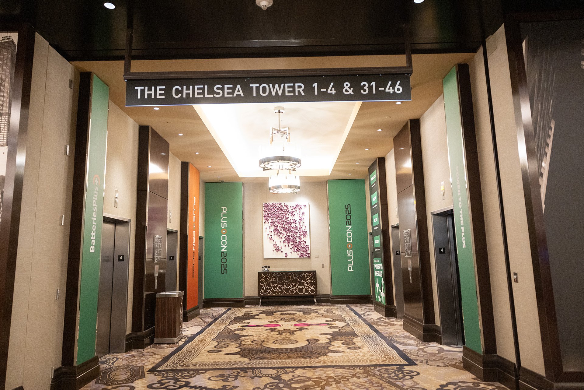 Elevator lobby at Chelsea Tower with signs indicating floors 1-4 and 31-46, decorative carpet, and modern lighting fixtures.