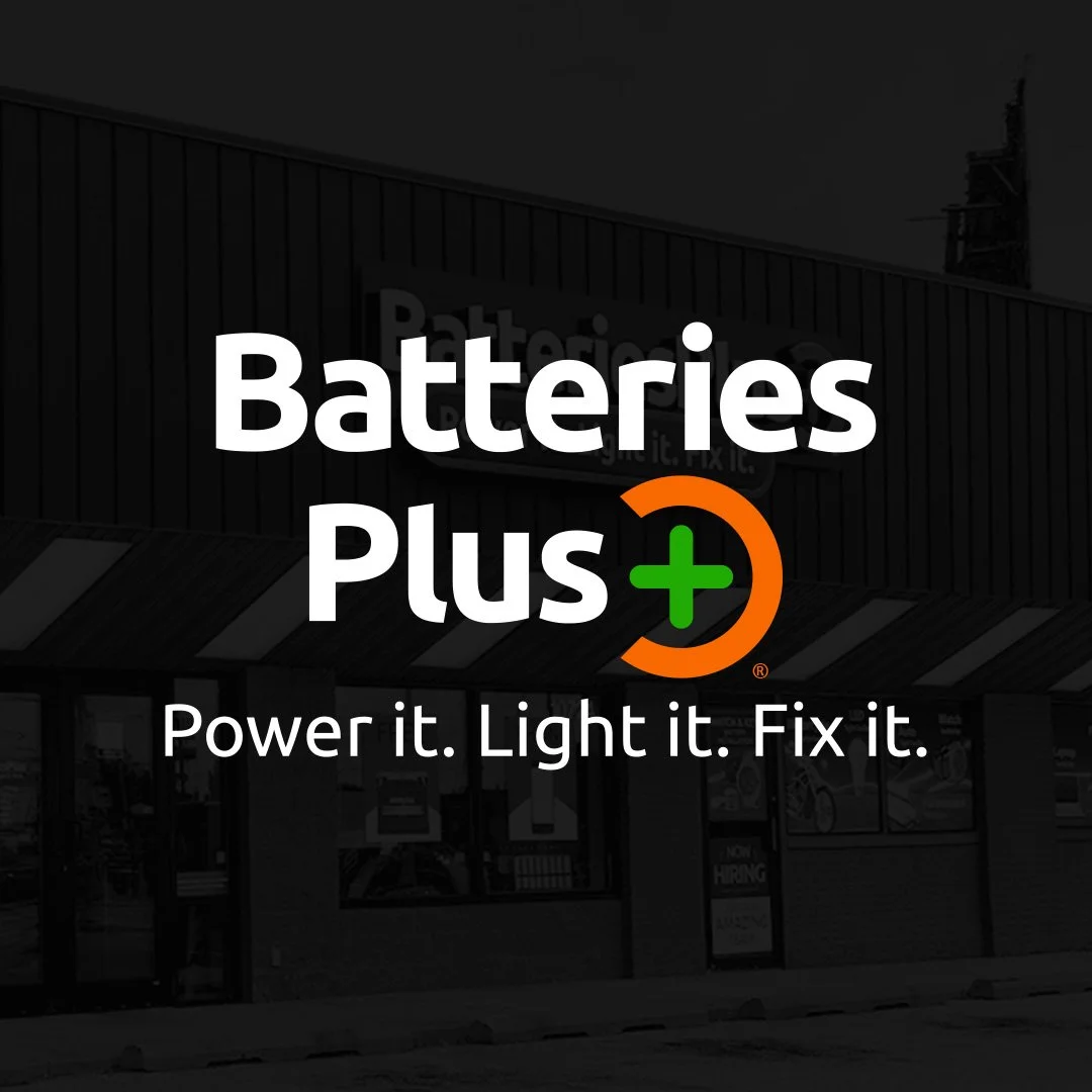 Logo for Batteries Plus with tagline 'Power it. Light it. Fix it.' in front of a store building.