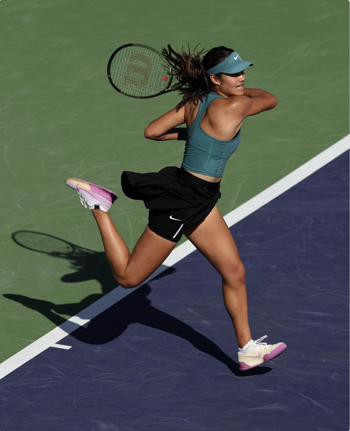 Tennis player running on court with tennis racket.