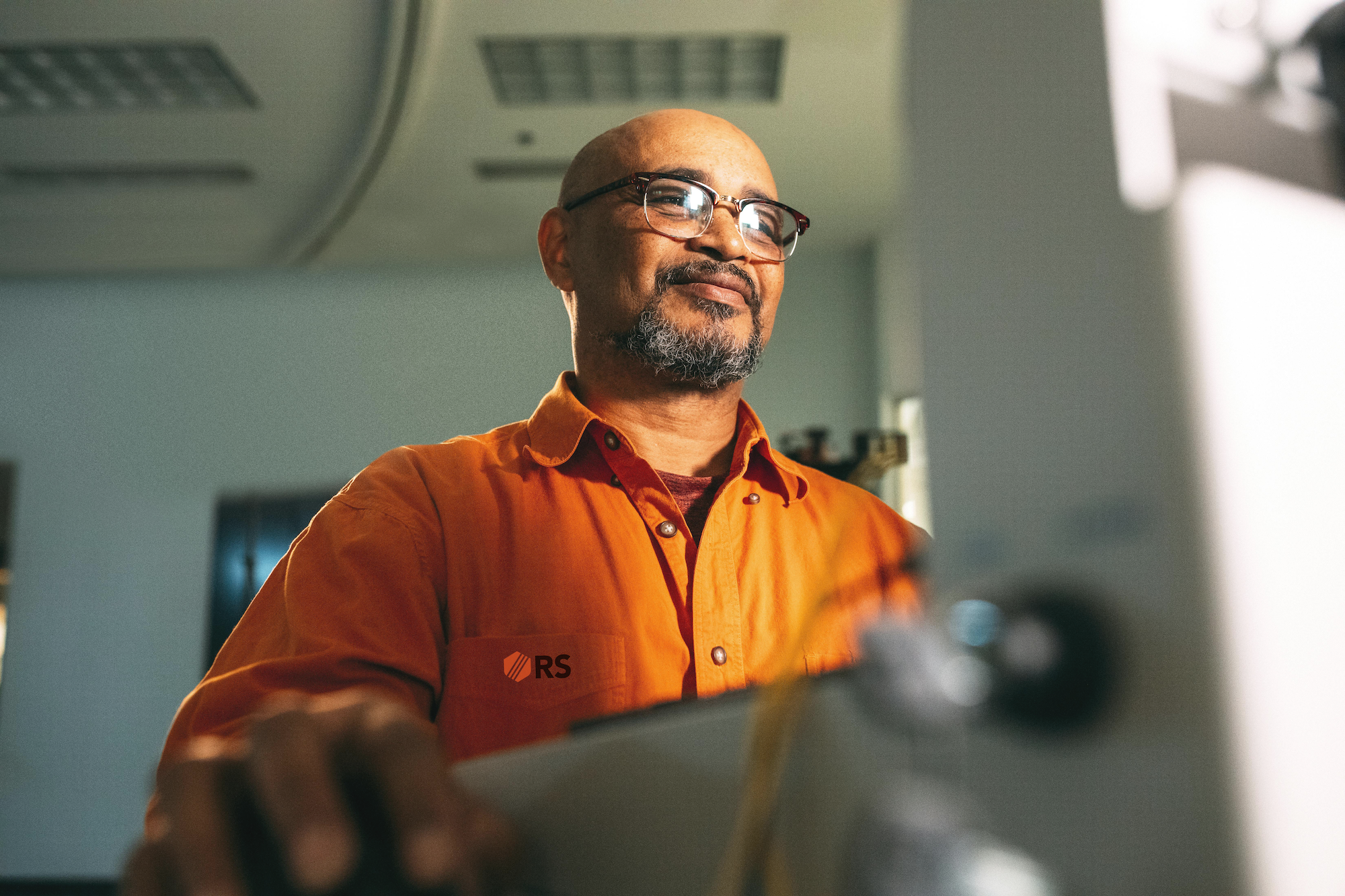 man with orange shirt and glasses with Relyt Security Logo on shirt