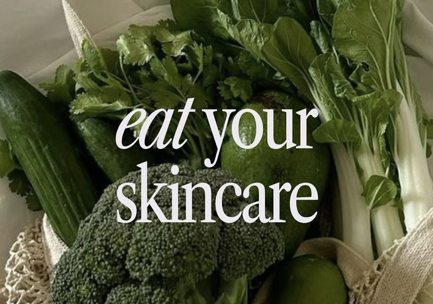 A basket of fresh vegetables, including cucumbers, broccoli, cilantro, and bok choy, with the text 'eat your skincare' overlaid.