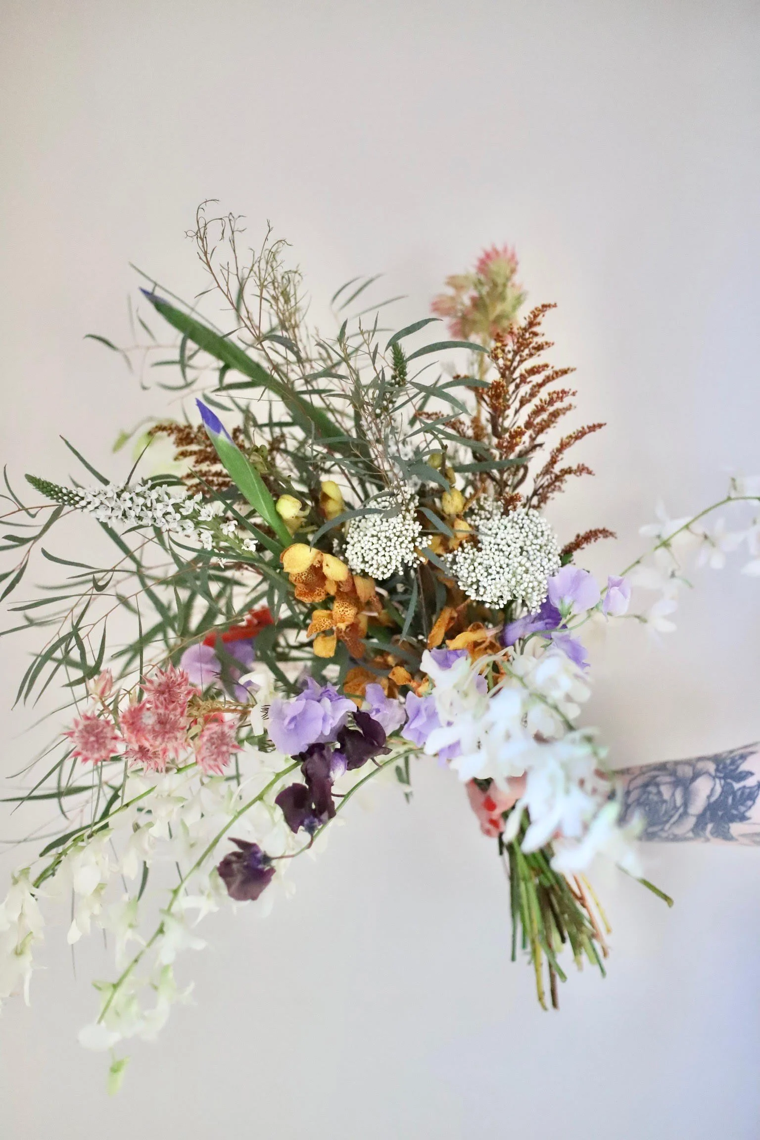 Colorful mixed wildflower bouquet with various flowers and greenery