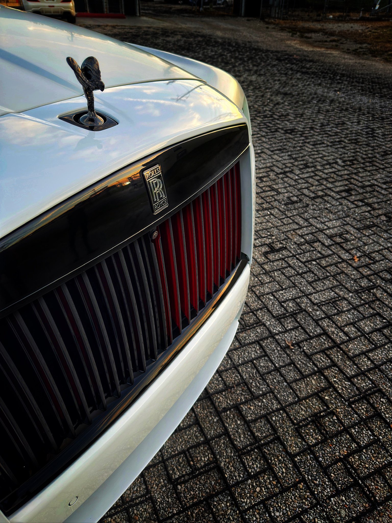Close-up of the custom front grille and hood ornament of a stealth PPF wrapped Rolls-Royce Cullinan