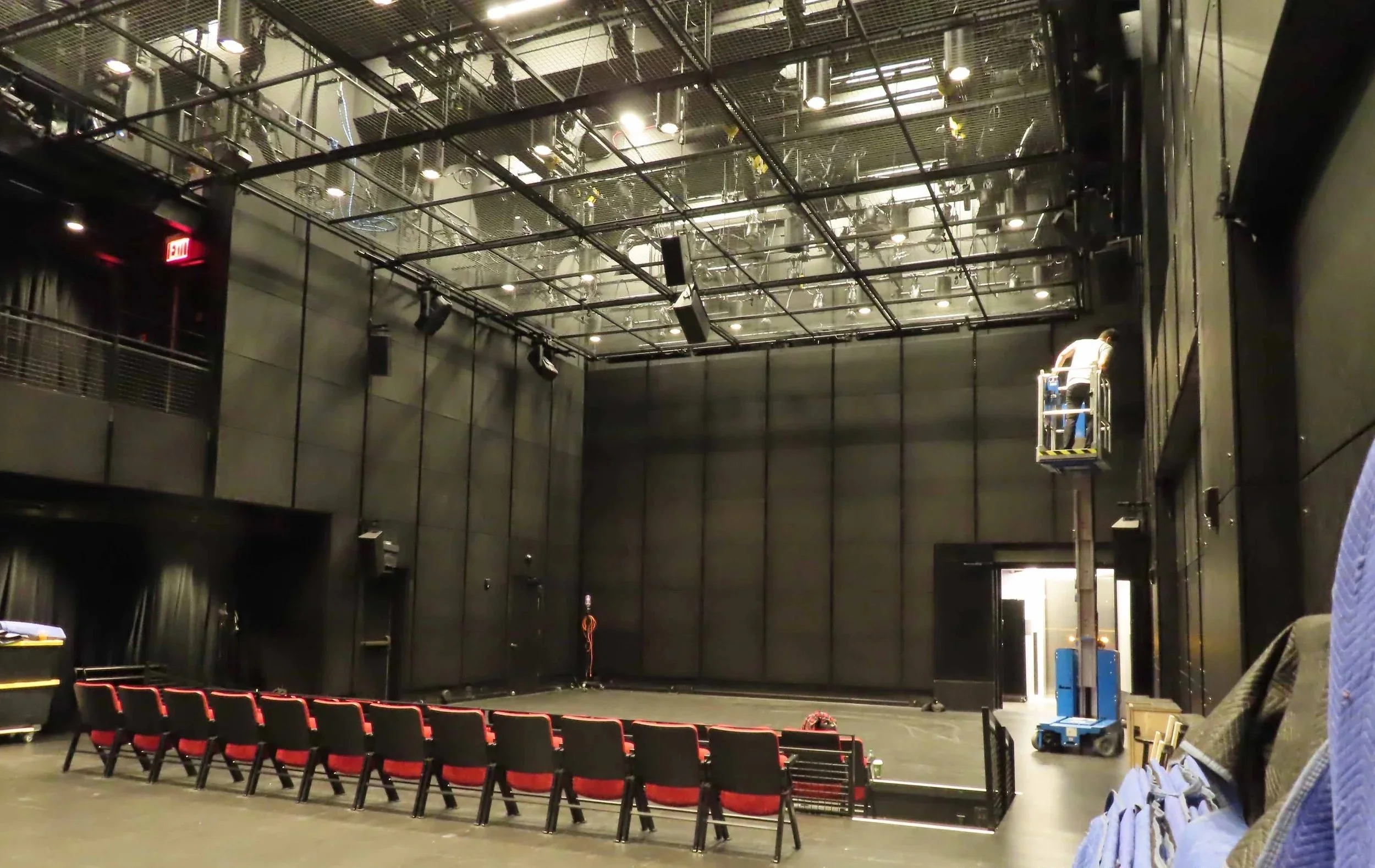 Large black box theater space, with grid for lighting and sound.