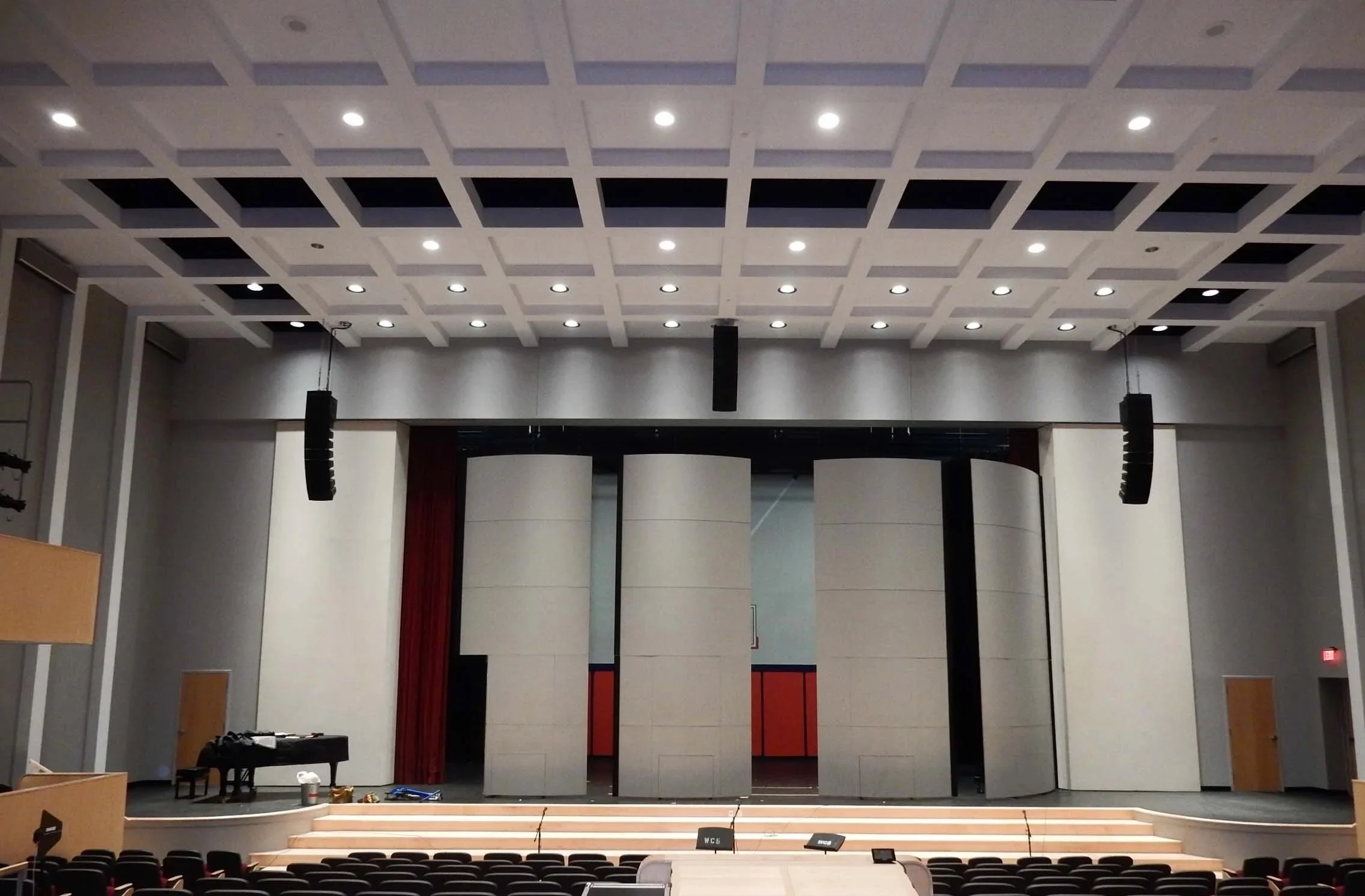 Large concert hall, with white walls. From back of theater towards stage.