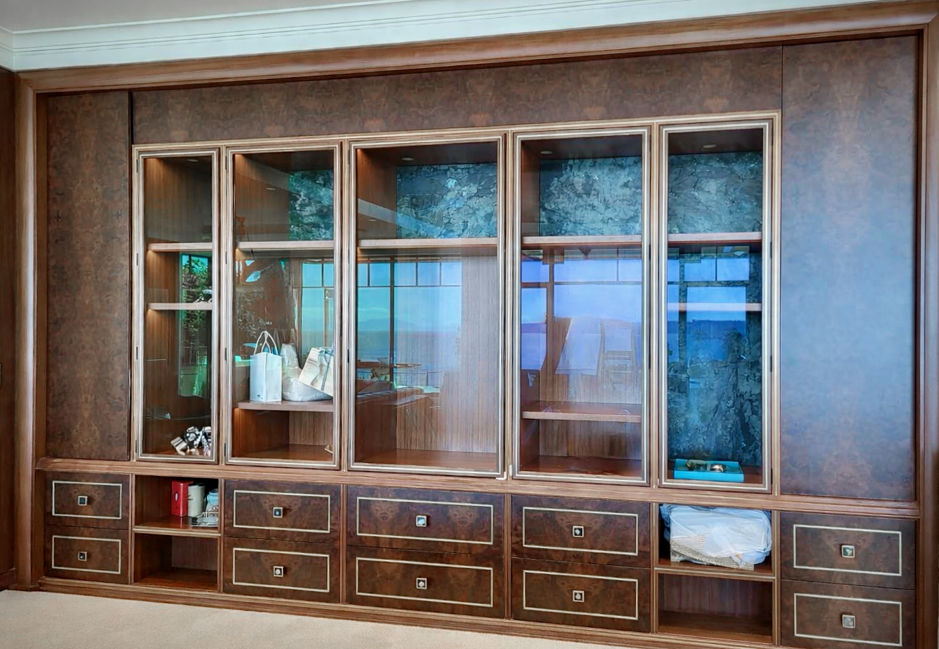 Prior fabrication experience.
Black walnut burl dining cabinet with book-matched panels, brass inlay, and glass display doors.